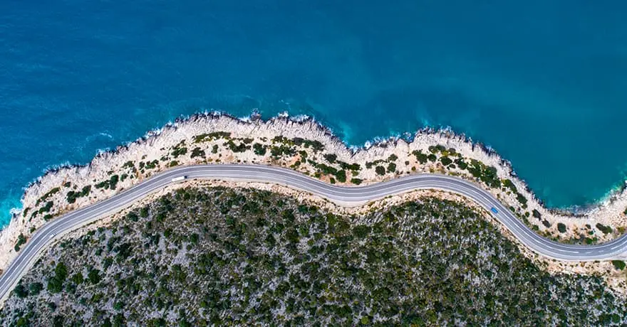a road with a body of wateruşak araba kiralama fiyatları